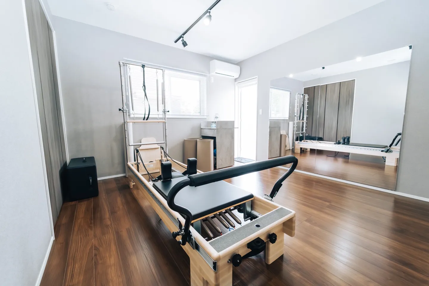 Yüka Pilates のスタジオ全景。リフォーマーの奥の壁一面が鏡になっていて、天井にライティングレールが付いている