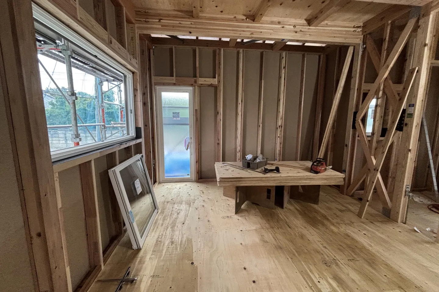 建築中のスタジオ。柱と梁がむき出しで、床に合板が張られた状態