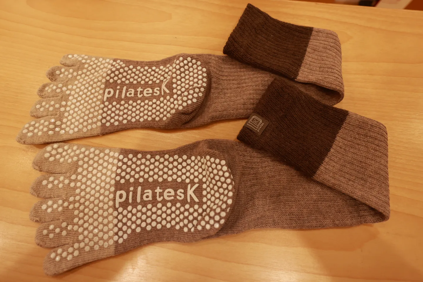 受付で買った pilates K の5本指の靴下。口ゴムがこげ茶で、足裏に滑り止めと pilates K のロゴがある