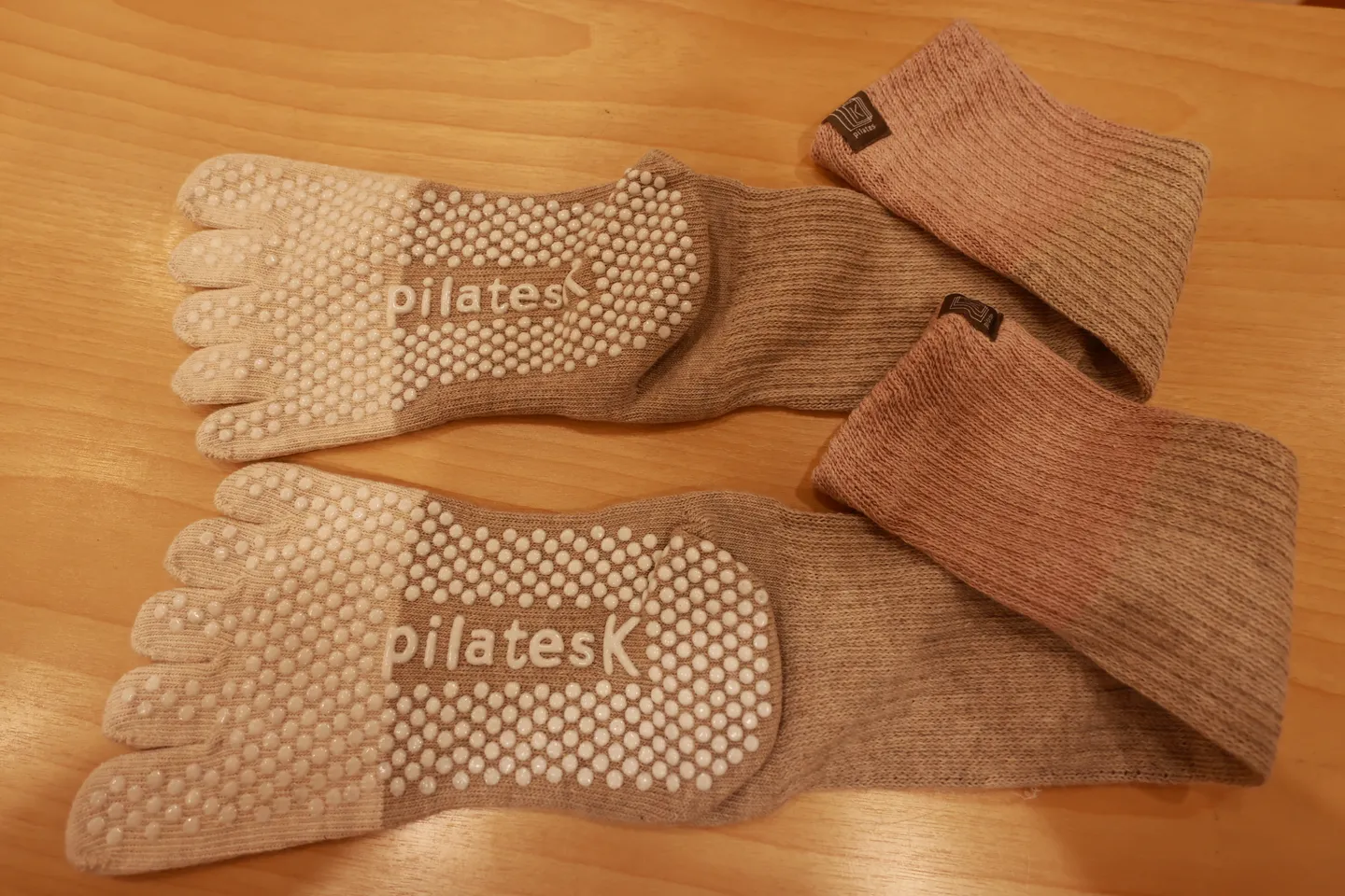 受付で買った pilates K の5本指の靴下。口ゴムがくすんだピンクで、足裏に滑り止めと pilates K のロゴがある