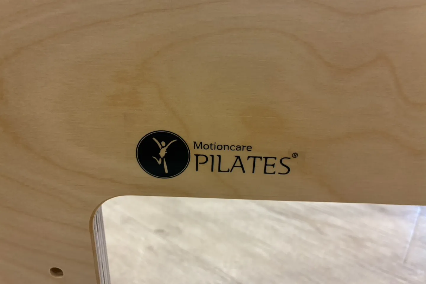 リフォーマーの木枠に入った「Motioncare PILATES」のロゴ
