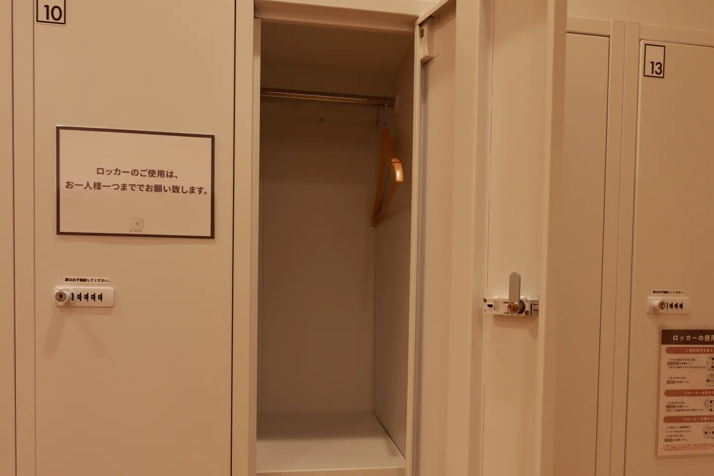 女性用の更衣室のロッカーを開けたところ。中にハンガー掛けと棚があり、扉にダイヤル式の鍵が付いている